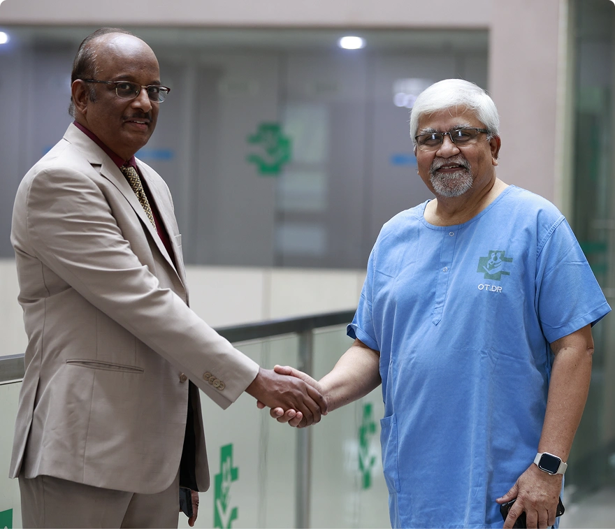 Two medical professionals shaking hands in a hospital corridor setting